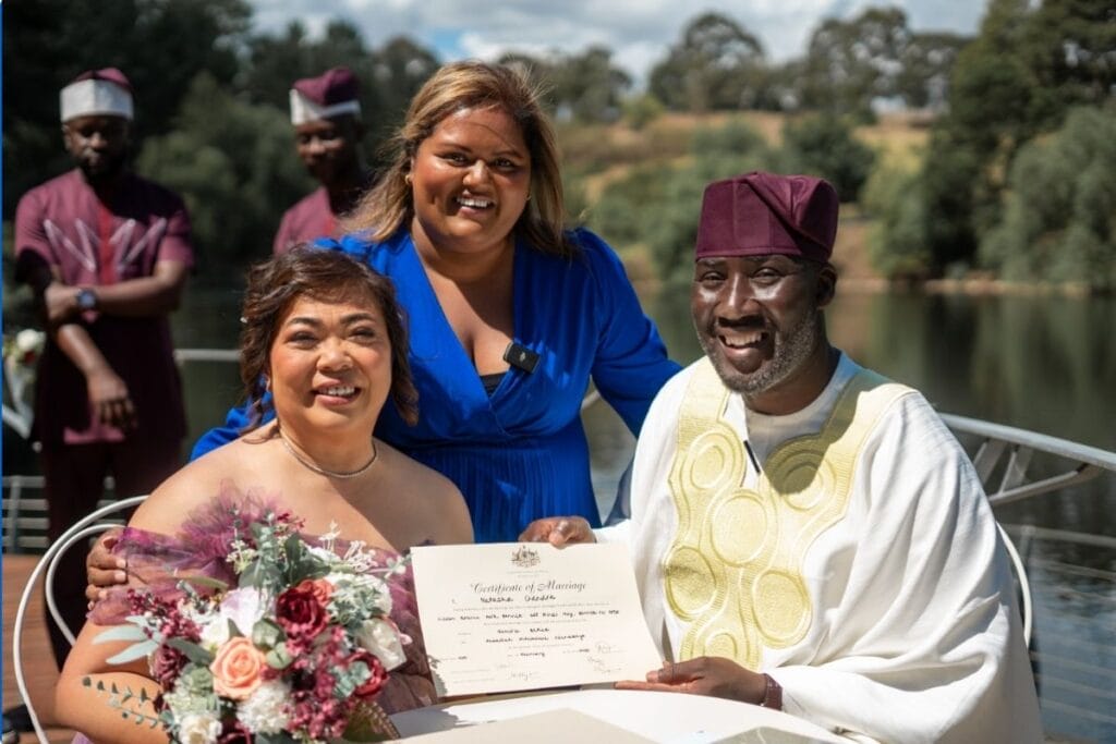 Celebrant Natasha Chandra with a couple. The bride is Asian and the groom is in African cultural dress