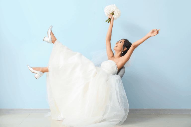 Happy bride leaning back in a chair in celebration against a blue backgroun