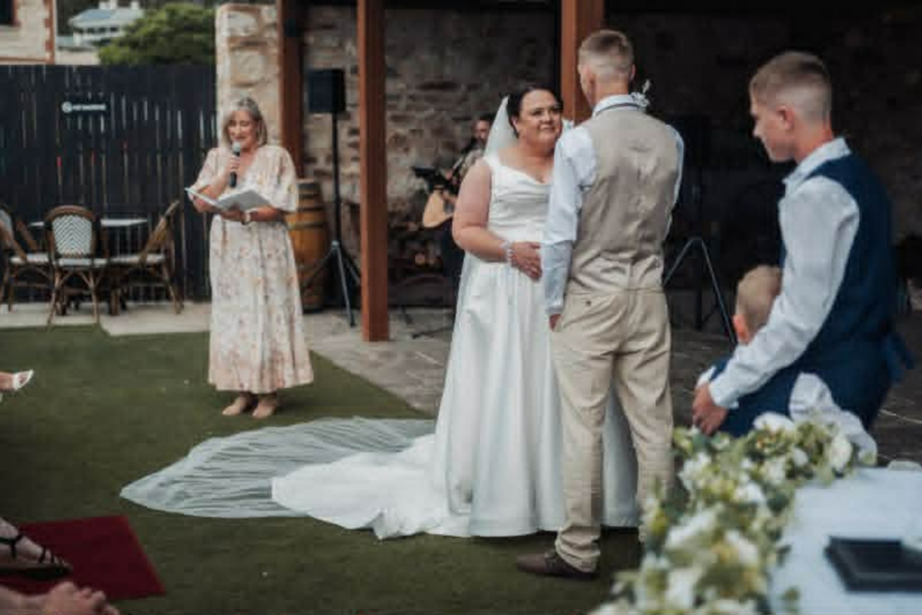Barossa Celebrant and teacher Jo Cross delivering a wedding ceremony next to a bride and groom